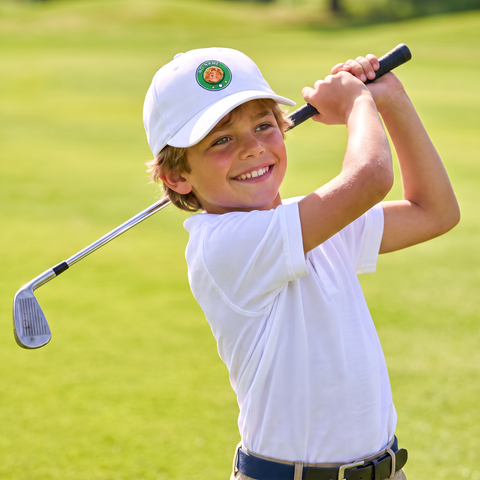 Kid swinging a golf club in the Super Golfers cap